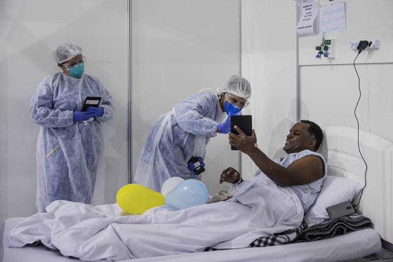 Humberto de Oliveira,62, fala com seus familiares por vídeo-chamada cercado por enfermeiros, durante comemoração de seu aniversário no hospital de campanha do Pacaembu em São Paulo
