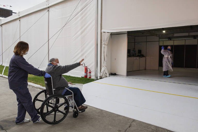 Antonio Candido Dias,77, vítima da Covid-19, se despede de uma enfermeira após receber alta, no hospital de campanha do Pacaembu em Sao Paulo