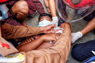 A injured man lies on the ground after the police fired rubber bullets during protests against the military coup, in Mandalay