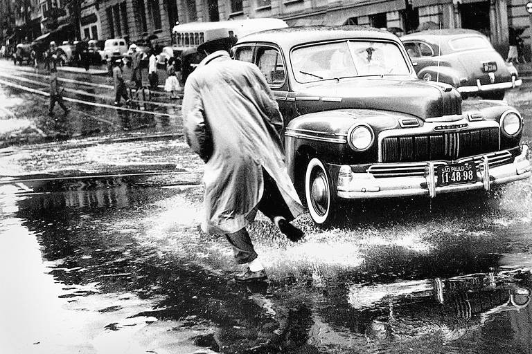 Pedestre tenta evitar poça d’água no centro da cidade de São Paulo, em fevereiro de 1964 