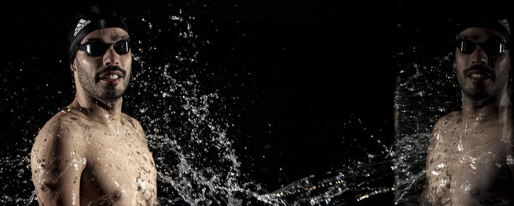 Daniel Dias, de 32 anos e o maior medalhista da natação paraolímpica mundial, em retrato para a Folha frente à frente com seu próprio reflexo e com água sendo jogada em seu rosto