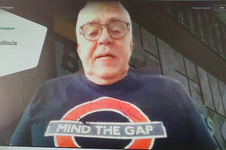 Imagem de um notebook com um homem que veste uma camisa escrito 'mind the gap' na tela