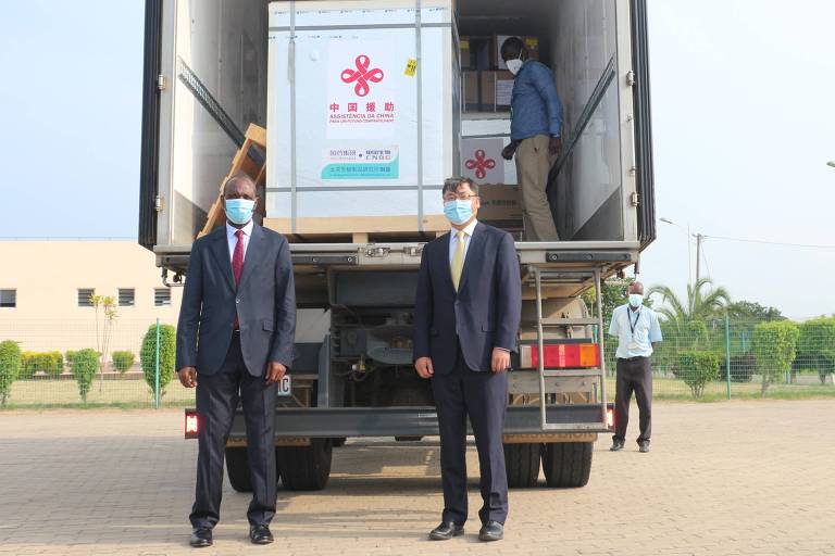 O primeiro-ministro do Moçambique, Carlos Agostinho do Rosario (esq.), e o embaixador da China no país africano, Wang Hejun, em frente a lote de vacinas contra a Covid-19 doado por Pequim