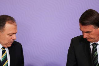 Brazil's President Jair Bolsonaro and Brazil's Health Minister Eduardo Pazuello react during a ceremony to announce a mass coronavirus disease (COVID-19) immunization program, at the Planalto Palace in Brasilia