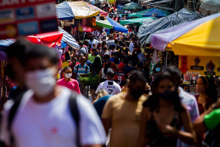 Multidão caminha em feira de Manaus, alguns usando máscara