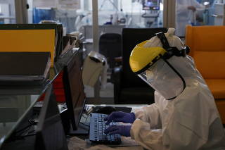 Health staff types in a computer at the coronavirus disease (COVID-19) dedicated ICU unit of the Tras-Os-Montes E Alto Douro Hospital, in Vila Real
