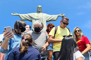 Visitantes com máscaras de pano e sem máscaras no Cristo Redentor, no Rio