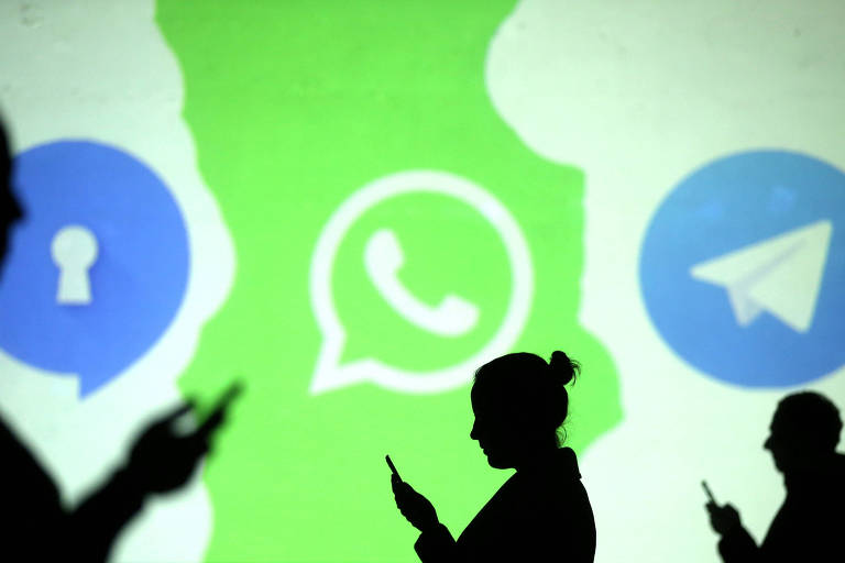 Silhuetas de pessoas com telefones celular próximas aos logotipos dos aplicativos de mensagem Signal, WhatsApp e Telegram