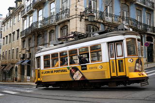 People wearing protective masks rides a tram in Lisbon downtown amid the coronavirus disease (COVID-19) pandemic, in Lisbon