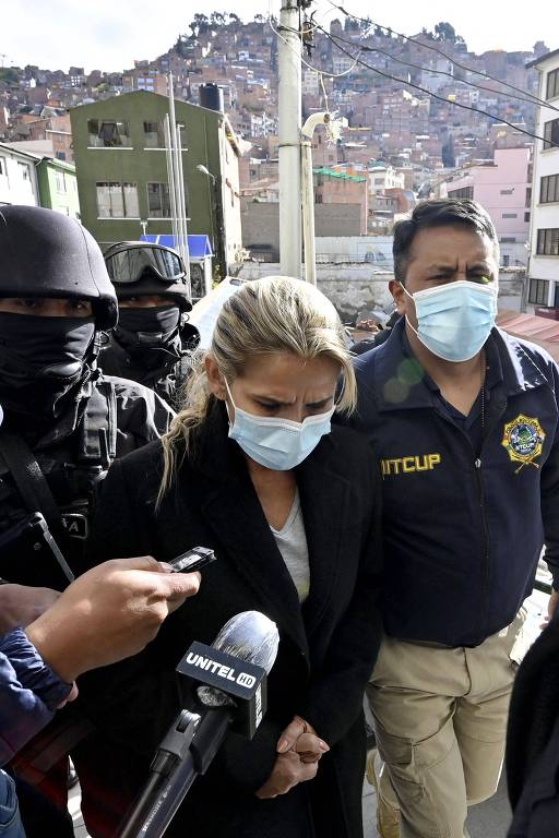 Jeanine Añez, ex-presidente interina da Bolívia, é escoltada pela polícia em La Paz. Ela está presa sob acusações de "sedição, conspiração e terrorismo"
