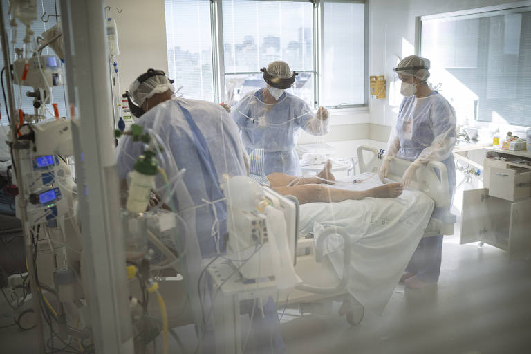 Enfermeiros e médicos atendem paciente com Covid-19 