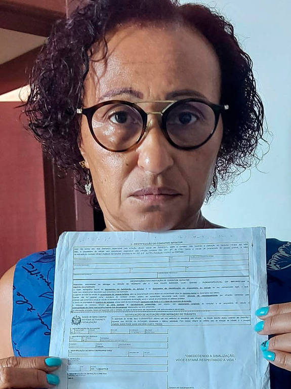 Carmen Vieira mostra a multa que recebeu após participar de carreatas contra Bolsonaro em Santa Catarina

