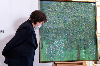 French Culture Minister Roselyne Bachelot stands next to the painting 