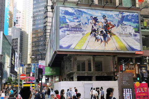 People walk below a billboard ad of fantasy game 