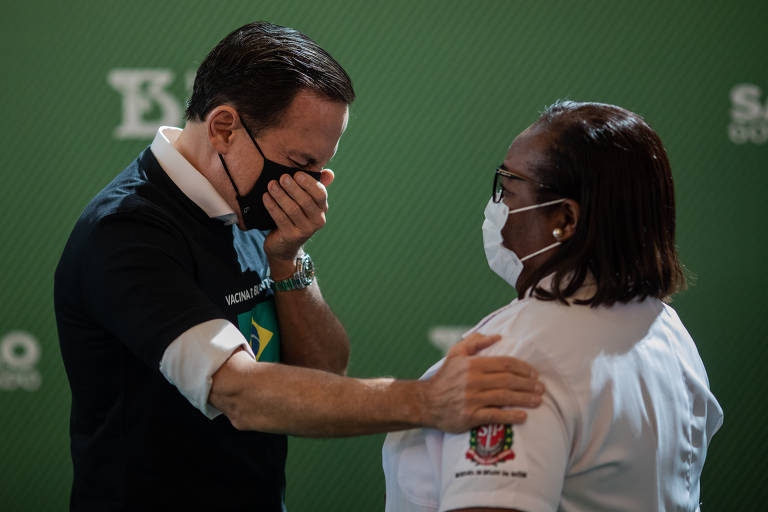 O governador de São Paulo, João Doria, chora após a enfermeira do hospital Emílio Ribas Monica Calazans se tornar a primeira brasileira a ser vacinada contra a Covid-19 no país, em 17 de janeiro
