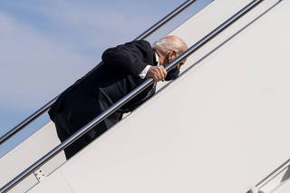 President Joe Biden stumbles as he walks up the steps of Air Force One at Joint Base Andrews, Md, for a trip to Atlanta, March, 19 2021. (Doug Mills/The New York Times)