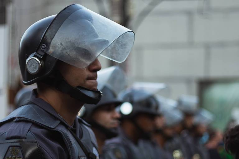 Linha de policiais da Força Tática, usando capacetes