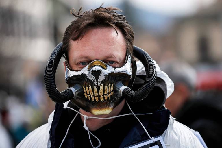 Manifestante usa máscara durante protesto em Liestal, na Suíça, contra as medidas restritivas para controle da pandemia da Covid-19