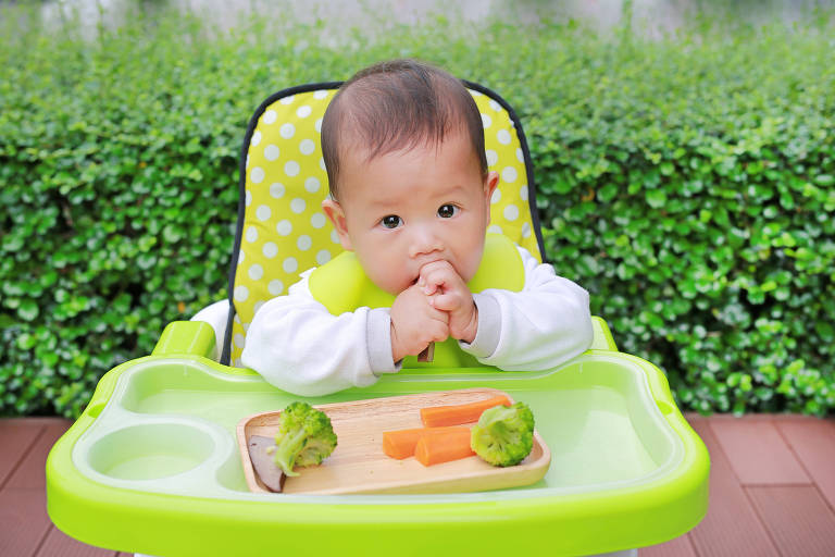 Asian infant baby boy eating by Baby Led Weaning (BLW). Finger foods concept.