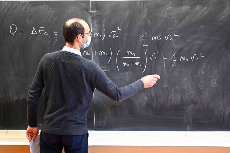 Professor escreve equação em lousa