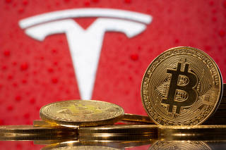 FILE PHOTO: FILE PHOTO: Representations of virtual currency Bitcoin are seen in front of Tesla logo in this illustration