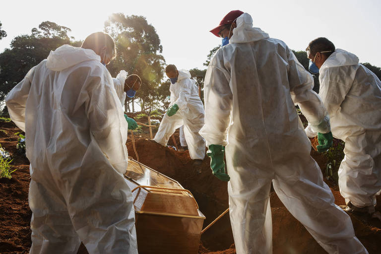 Sepultadores enterram vítima de Covid-19 no cemitério da Vila Formosa.
