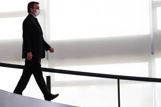 Brazil's President Jair Bolsonaro arrives at a ceremony to announce measures by Caixa Economica bank in support of philanthropic hospitals, in Brasilia