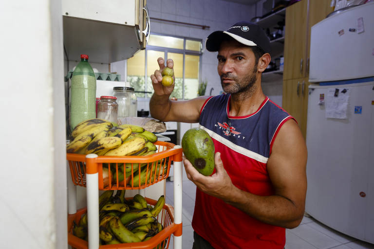 Moises Massi exibe frutas apanhadas em terreno baldio para dar à mulher e aos filhos
