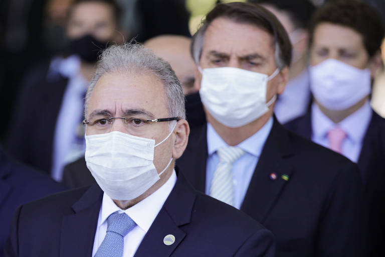 O ministro da Saúde Marcelo Queiroga à frente do presidente Jair Bolsonaro