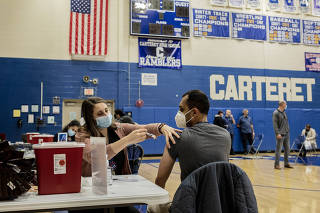 A Penn Medicine Princeton Health professional administers a COVID-19 vaccine during a mass vaccination event for teachers at Carteret High School in Elizabeth, N.J., on Thursday, April 1, 2021. (Bryan Anselm/The New York Times)