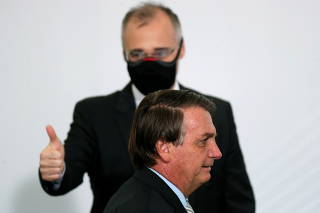 Brazil's Justice Minister Andre Luiz de Almeida Mendonca gestures next to Brazil's President Jair Bolsonaro after the opening of the forum 'Control in the Fight against Corruption 2020' at the Planalto Palace in Brasilia