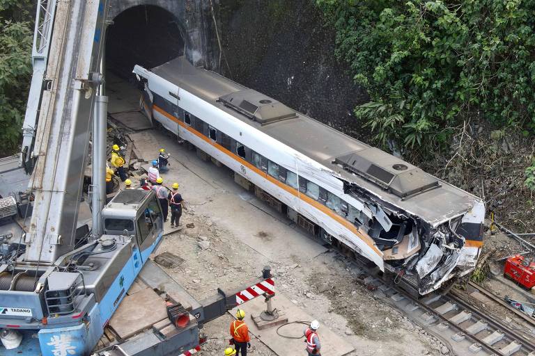 Trabalhadores checam o vagão danificado do trem envolvido no acidente nas montanhas de Hualien, em Taiwan