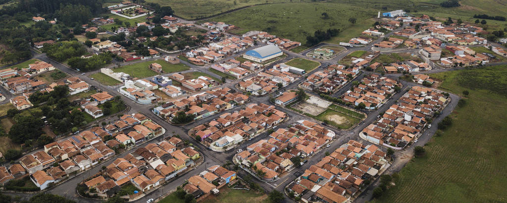 Vista aérea de cidade com casas e gramadps