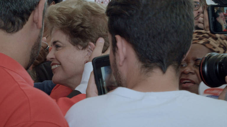Dilma Rousseff em meio a apoiadores e jornalistas, na saída do palácio