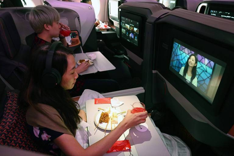 Passageiros assistem a filmes em voo da Singapore Airlines 