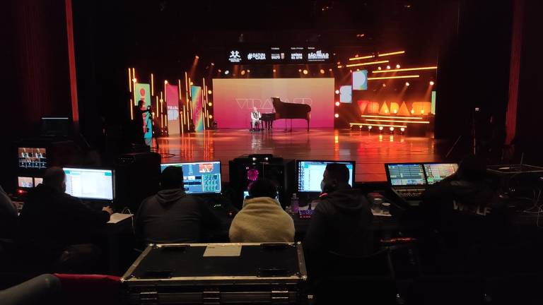 Imagem mostra área que comanda a transmissão e gravação de um espetáculo, que acontece no palco, ao fundo
