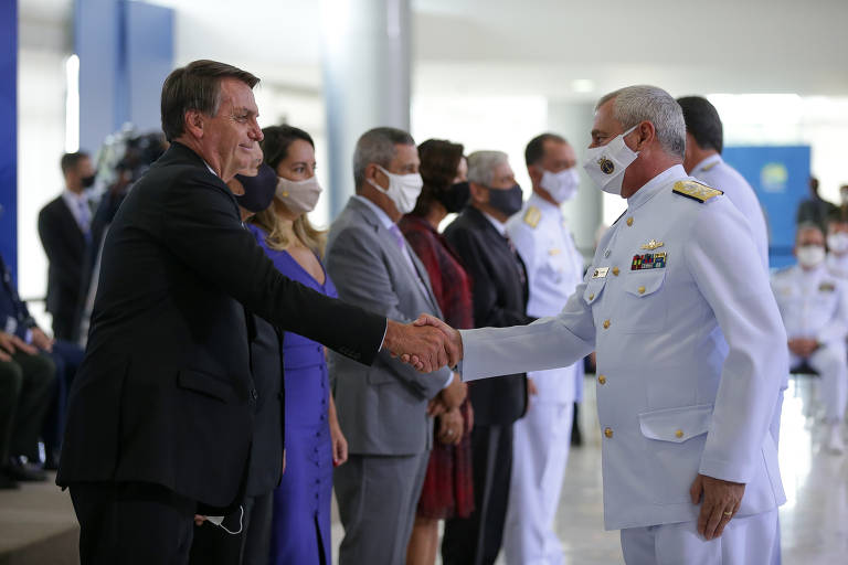 O presidente Jair Bolsonaro pega na mão de militares apesar do auge da pandemia. Cumprimento ocorreu durante cerimônia em que os oficiais generais foram promovidos, no Palácio do Planalto.