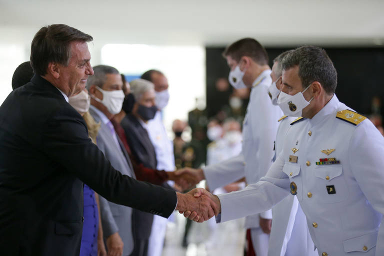 O presidente Jair Bolsonaro, sem máscara, pega na mão de militares, apesar do auge da pandemia. Cumprimento ocorreu durante cerimônia em que os oficiais generais foram promovidos, no Palácio do Planalto.