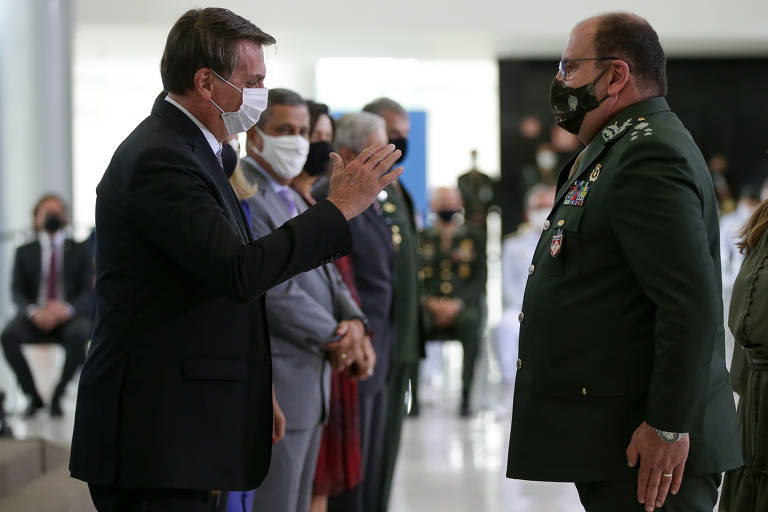 O presidente Jair Bolsonaro pega na mão de militares, apesar do auge da pandemia. Cumprimento ocorreu durante cerimônia em que os oficiais generais foram promovidos, no Palácio do Planalto.