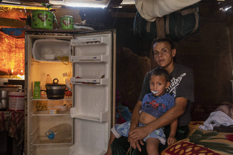 Família com geladeira quase vazia em barraco no Jardim Papai Noel, em Parelheiros, zona sul de São Paulo