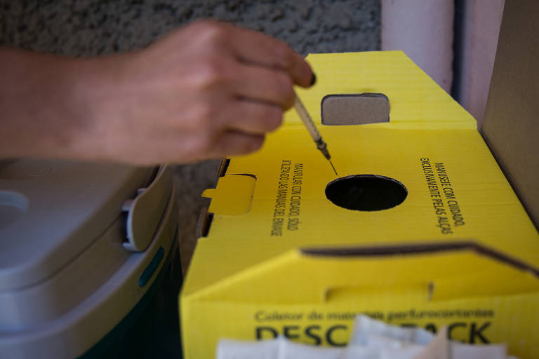 Profissional de saúde descarta a seringa usada após a aplicação