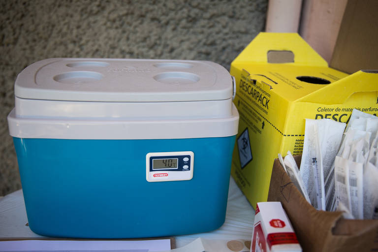 Caixa térmica, seringas esterilizadas e a caixa para descarte