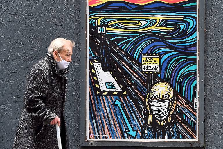 Pedestre passa por imagem que cita o célebre quadro "O Grito", em Glasgow na Escócia, após novas restrições para impedir contágio