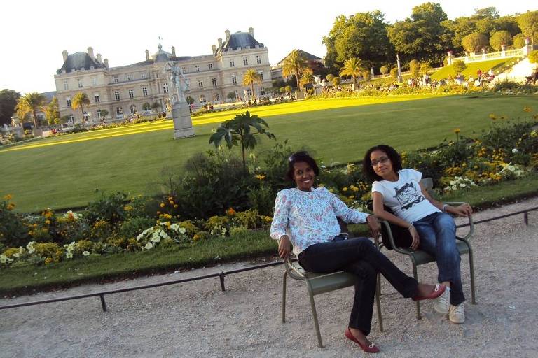 Isabelle e a mãe sentadas em um banco de um jardim em Paris