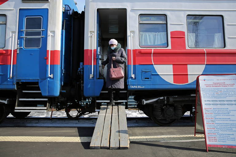 Mulher deixa vagão de trem médico que fornece serviços de saúde, incluindo aplicação da vacina contra a a Covid-19, em uma estação ferroviária na cidade de Tulun, na Rússia