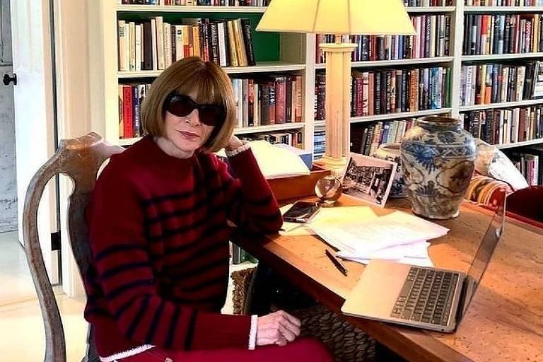 No escritório da editora da Vogue dos Estados Unidos Anna Wintour, usando seu visual carimbado de óculos de sol e cabelo curto, as estantes cheias de livros dividem espaço com uma mesa ampla e luz aconchegante