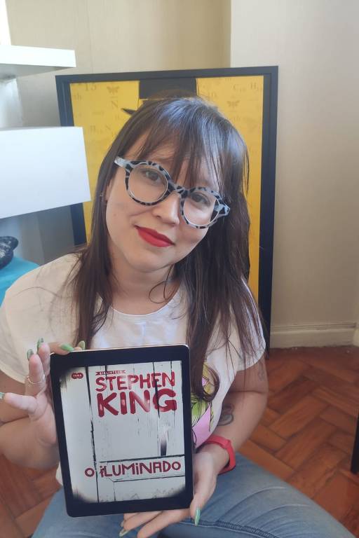 Tamiris Amaral, 33, de São Paulo (SP), com 'O Iluminado', de Stephen King, no tablet