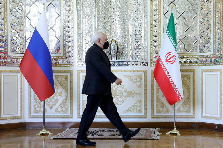O ministro das Relações Exteriores do Irã, Mohammad Javad Zarif, passa pelas bandeiras iraniana e russa antes de se reunir com o chanceler da Rússia, Sergei Lavrov, em Teerã