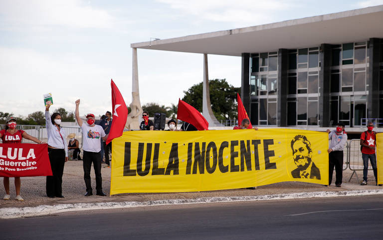 Diante do STF, vários manifestantes, com bandeiras vermelhas com o nome de Lula e uma faixa com os dizeres "Lula Inocente" e o nome do ex-presidente