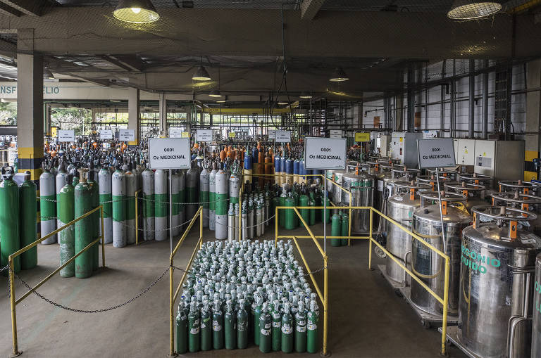 De depósito, cilindros de oxigênio medicinal são carregado em caminhões para serem levados até ponto de consumo